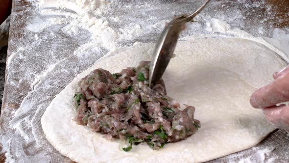 Chef make meat pies kutaba or chebureki, raw minced meat with onions and herbs filling dough. alt