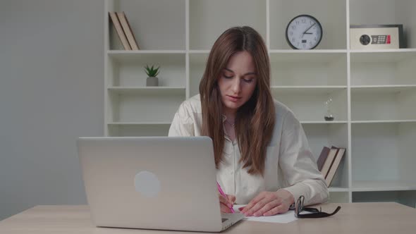 Young Woman Watching Internet Video Course Talking with Coach Using Laptop Sitting at Office Desk alt