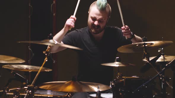 Drummer performing in a studio setting. alt