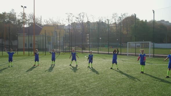 Kids Soccer Team During Warm Up on Football Field alt