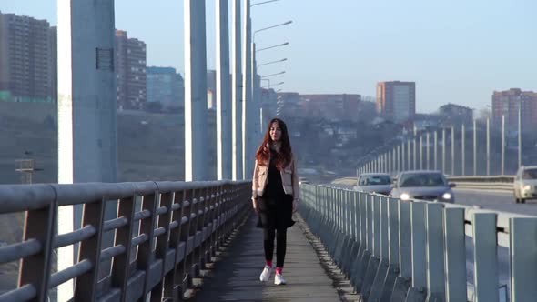 Young woman walking on the bridge in the city