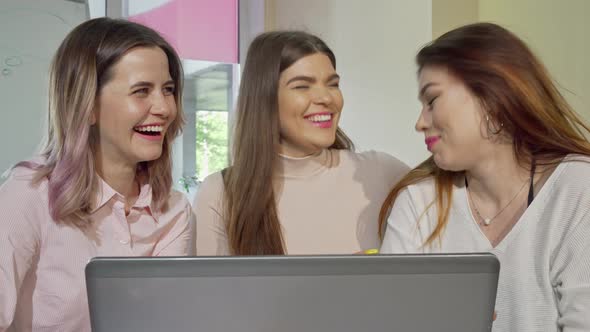 Three Charming College Girls Laughing and Talking While Studying Together alt