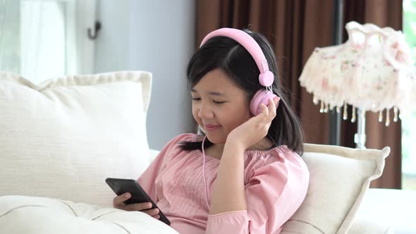 Beautiful Asian Girl Listening To Music  Sitting On A Sofa In The Living Room At Home  alt