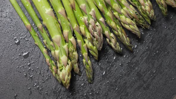 Raw Green Asparagus on Black Slate Background alt