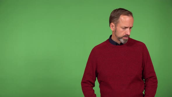 A Middleaged Handsome Caucasian Man Looks Seriously at the Camera  Green Screen Background