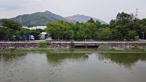 A dynamic horizontal aerial footage of a river near Yuen Long, Hong Kong. This shot showcases the mo alt