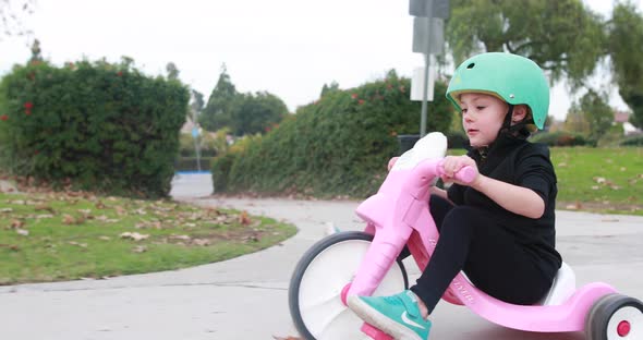 Girl Rides Tricycle At Park