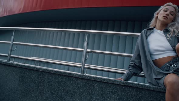 Attractive Woman Posing Urban Background Sitting Pose in Cityscape alt