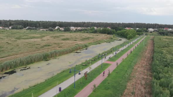 Woman is cycling on bicycle on cycle path. Female triathlete is training on road aero bike alt
