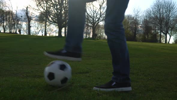 Man In Blue Jeans And Moccasins Juggling Black and White Classic Soccer Ball