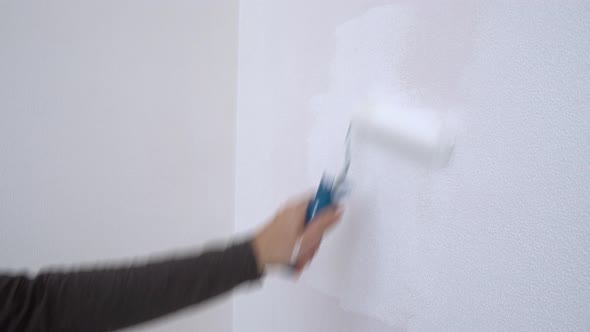 A Painter Paints A Wall White In A New Home