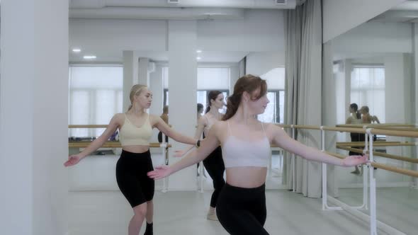 Three young girls dance in a white bright studio in front of a mirror. Slow motion, smooth motion. alt