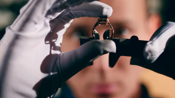 Golden Ring Is Getting Measured in the Hands of the Jeweler alt