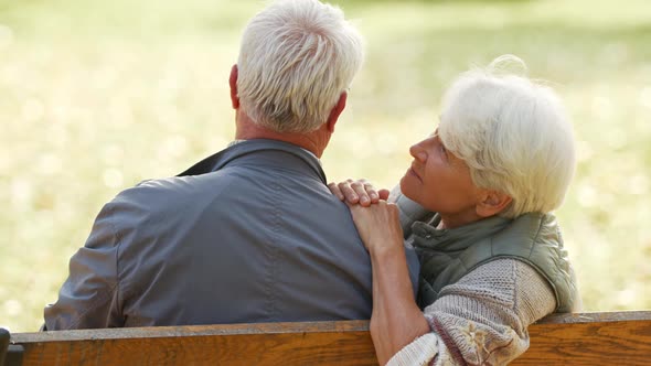 An Elderly Couple Sitting on the Bench in the Park alt