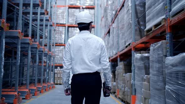 Follow footage of employees male warehouse worker engineer in hard hat working alt