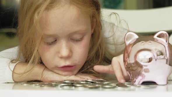Girl Preschooler Puts Money in a Piggy Bank Pink Pig