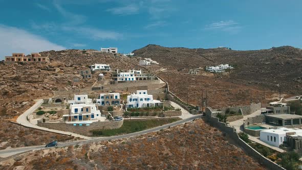 Dry Land, Brown Stones, Arid Bushes, Dusty Roads And White Villas