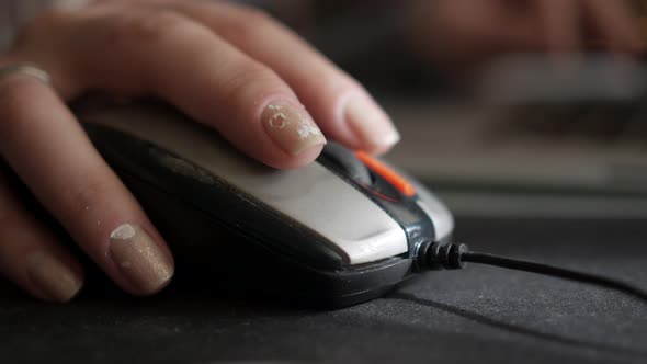 Close-up of a Girl with Dirty Nails Using a Computer Mouse