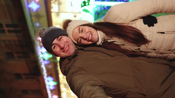 Vertical Shot of Young Couple Bloggers Stands Hugging Making Video Talking for Social Page  alt
