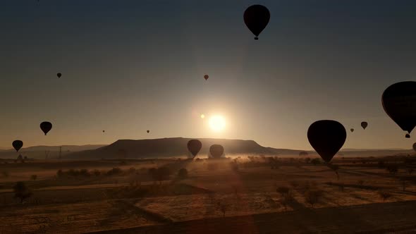 Silhouettes of Flying Hot Air Balloons Over Cappadocia Lands in Turkey on Sunset alt