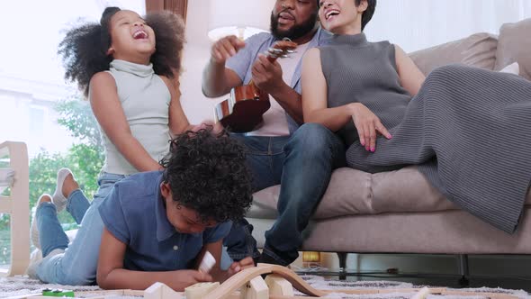 Love moment of African American family doing activity playing together on floor in living room