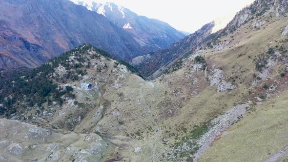 Refuge Espingo hiker shelter and Lac d'Espingo lake in Haute-Garonne, Pyrénées, France, Aerial dolly alt