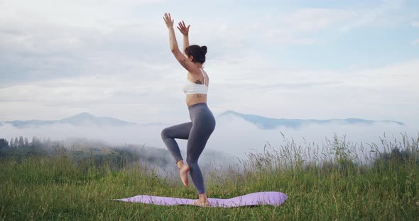 Woman Balancing on One Leg While Practising Yoga on Nature alt