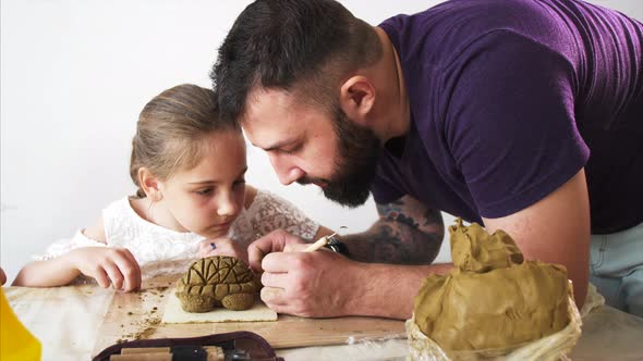 Teacher Explains and Shows His Pupil Girl How to Modeling a Toy From Clay