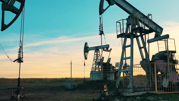 Oil Pumping Site with Pumpjacks and Male Workers. Crude Oil, Gas, Petroleum Prices Concept. alt