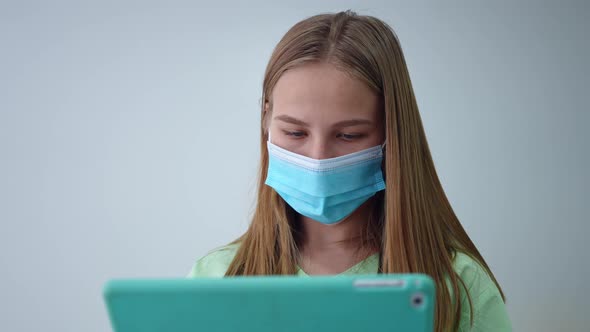 Closeup Portrait of Intelligent Young Woman in Uniform and Face Mask Checking Online Database on alt