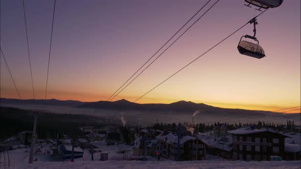 Cabins of Poma Lift Move Over Small Town on Snowy Mountain alt
