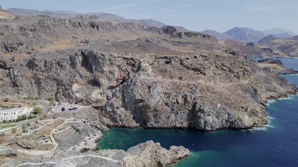 Drone footage of the Kalypso wild beach, Cretan village blue logons, coral reefs, rocky hills alt