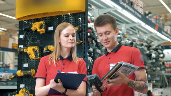 Young sales consultants guy and girl at work in a large building materials supermarket