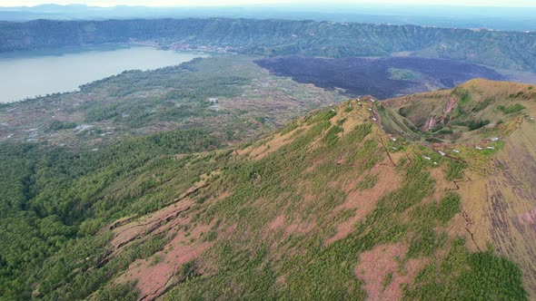 aerial pan left to right of Mount Batur volcano crater rim at sunrise in Bali Indonesia alt