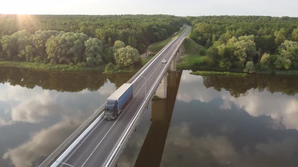 Semi Truck with Cargo Trailer Passing Highway Bridge over the river alt