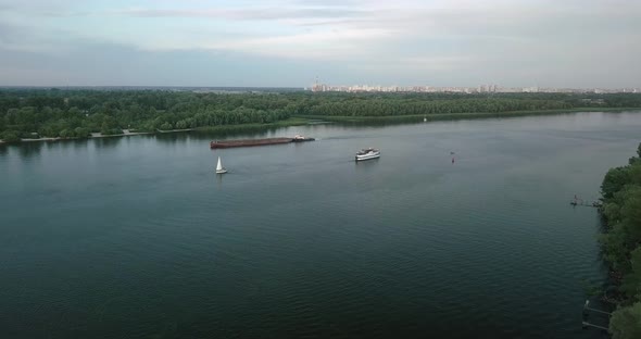 Drone Flight Over the River By Ships Walking Along It on a Cloudy Day. Ukraine