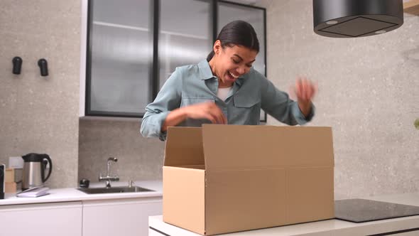 Multiracial Woman Unpacking Parcel Cardboard Box with Online Order