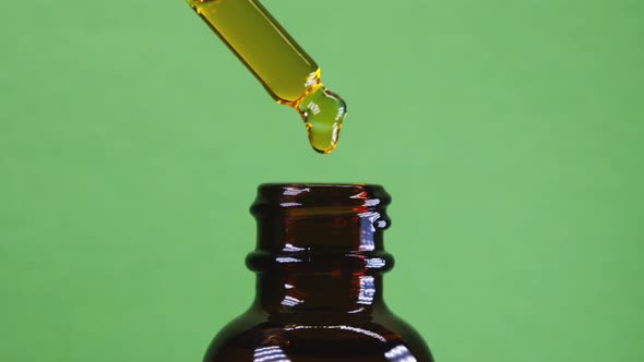 Organic Seed Oil Dripping From Pipette Into Jar alt