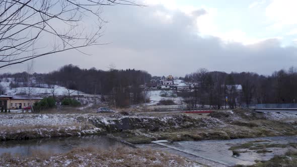 Limanowa, South Poland: Pan shot of a car driving in a mountain by the river in a country side alt