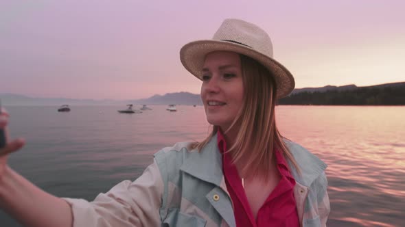 Portrait of Happy Woman Making Selfie Picture on Smartphone Camera Pink Sunset alt