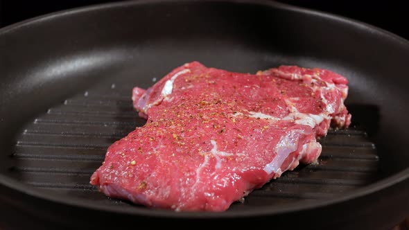 The Meat Steak Is Fried with a Leaf of Rosemary in Grill Pan