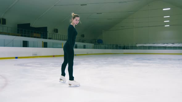 Caucasian figure skater stopping and spraying snow