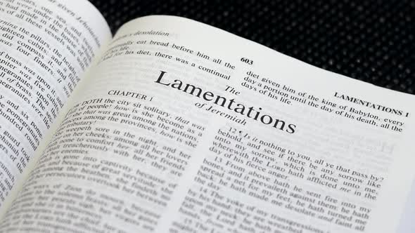 Close Up Shot of  Bible Page Turning to the book of Lamentations alt
