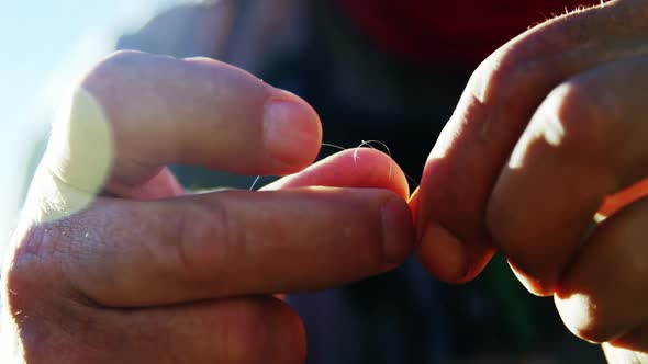 Fly fisherman preparing fishing line for fishing alt