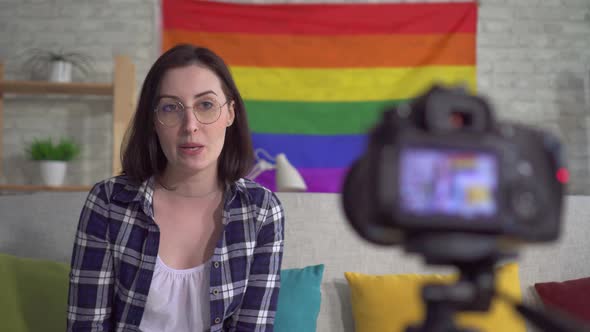 Young Pretty Woman Blogger in the Shirt on the Background of the Flag of the LGBT Records Video alt