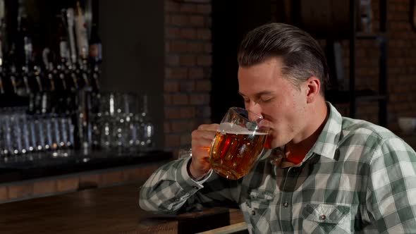 Handsome Happy Man Smiling Toasting His Beer Glass To the Camera alt