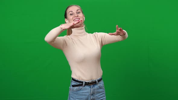 Woman with Toothy Smile in Earphones Imitating Waltzing on Green Screen alt