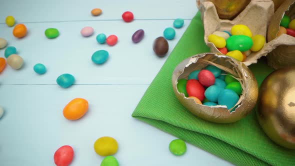 Golden Decorative Easter Eggs Filled with Colorful Candies on Wooden Table Close Up