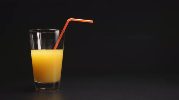 Orange juice disappear from a glass with a tube