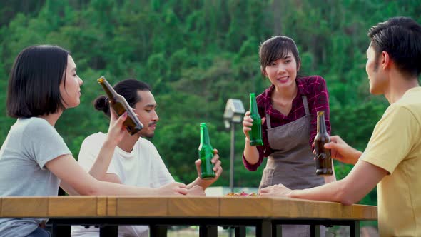 Group of Asian man and woman are having fun in new year party outdoor in the evening together. alt